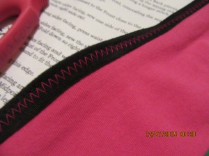 Contrast zig zag on the Fold OVer Elastic (FOE), deliberate design feature, not laziness in changing thread